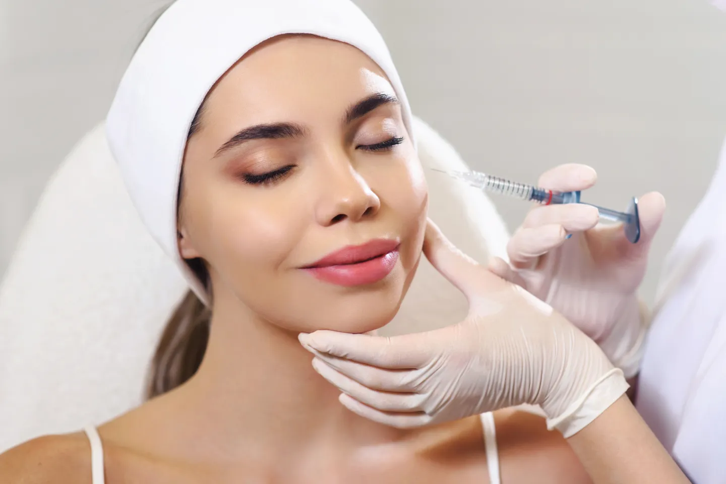 A woman at the dentists office chatting to her doctor and smiling with a toothy smile
